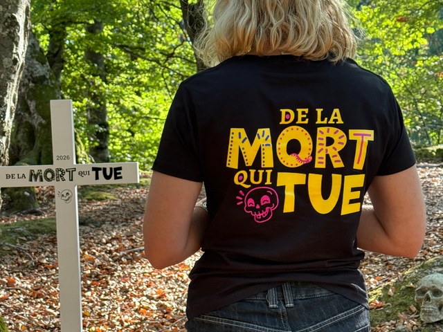 Dos du t-shirt De la mort qui tue Dos du t-shirt De la mort qui tue porté en forêt, avec la croix du jeu en arrière-plan
